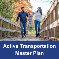 father and mother and child walking on a wood path