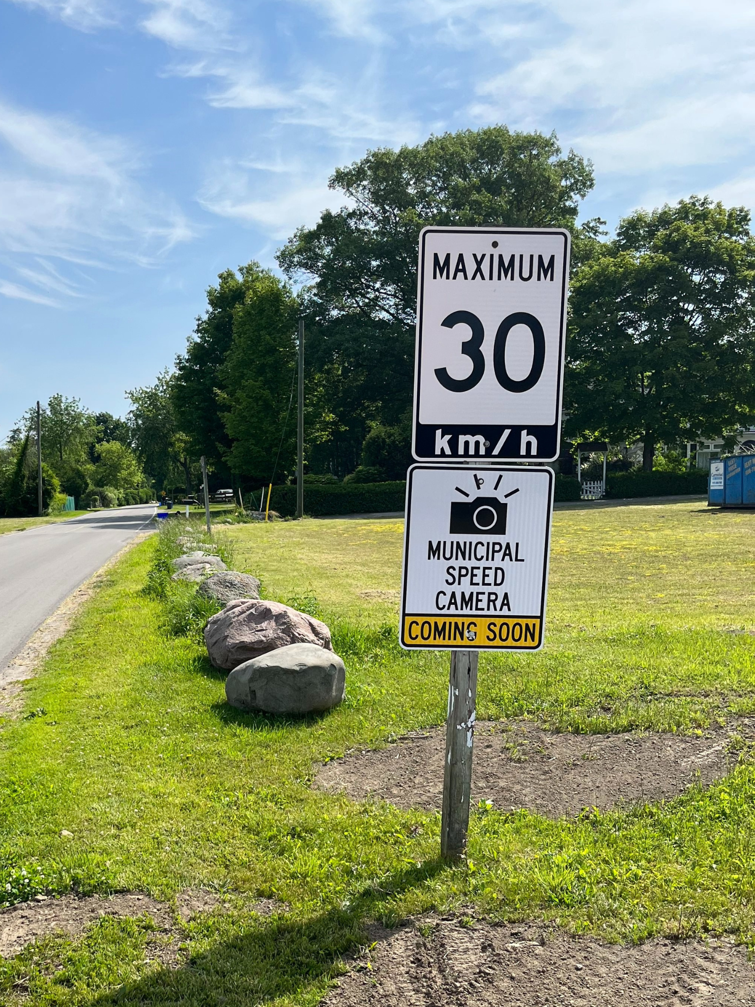 Sign on wooded pole that says maximum 30 km/hr Municipal Speed Camera Coming Soon