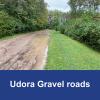 dirt and gravel road with pooled water with blue bar and text Udora Gravel Road